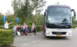 Culturele mobiliteit - kinderen wachten bij witte bus